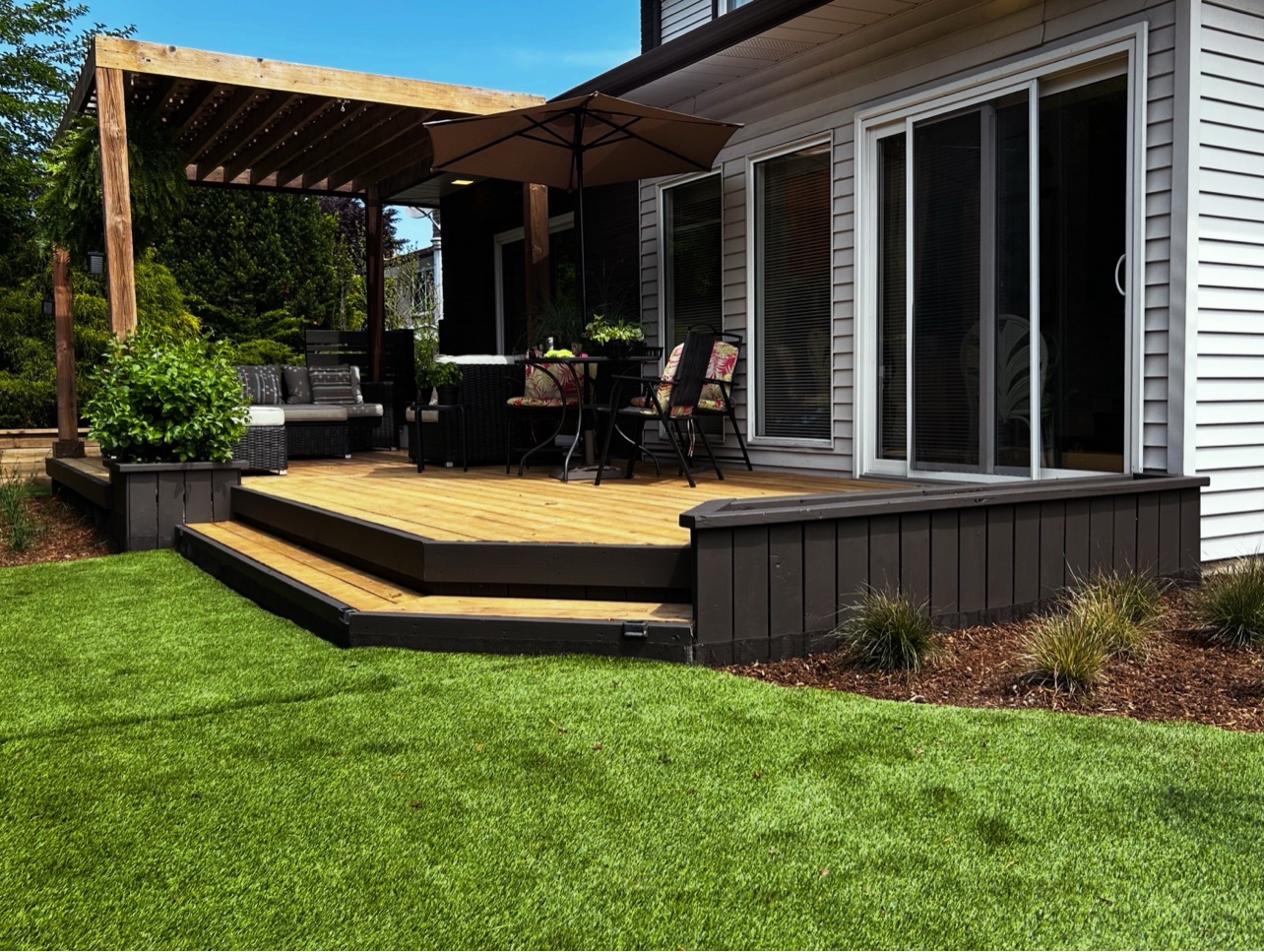 Finished re-boarded deck with dark skirting, furnished under a pergola