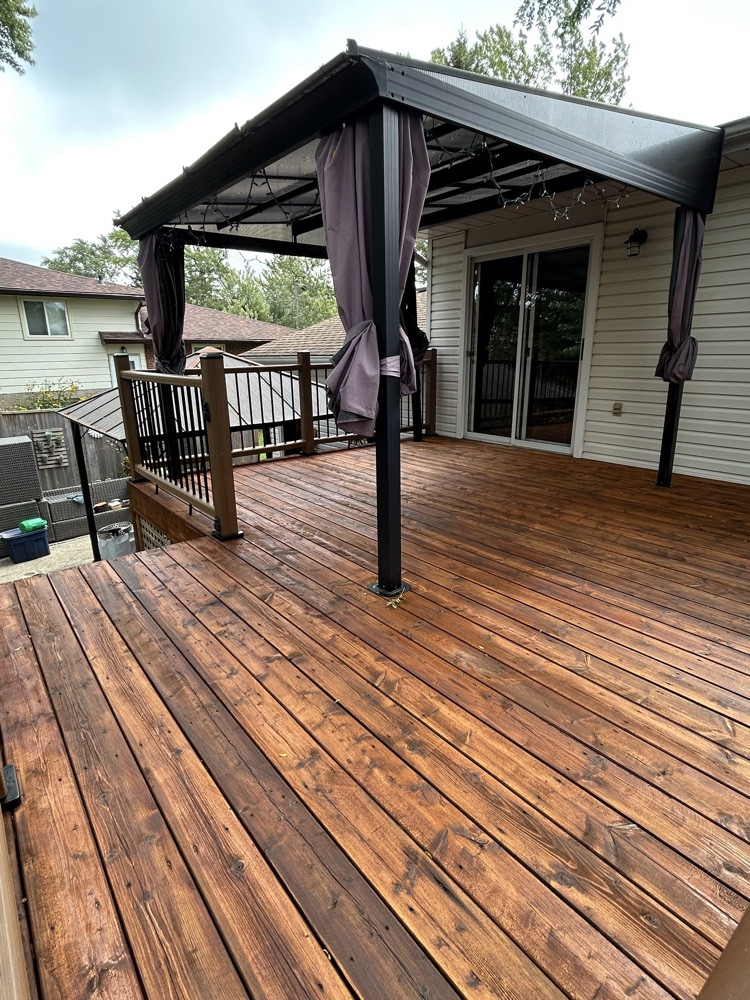 Restored stained wood deck with a covered seating area